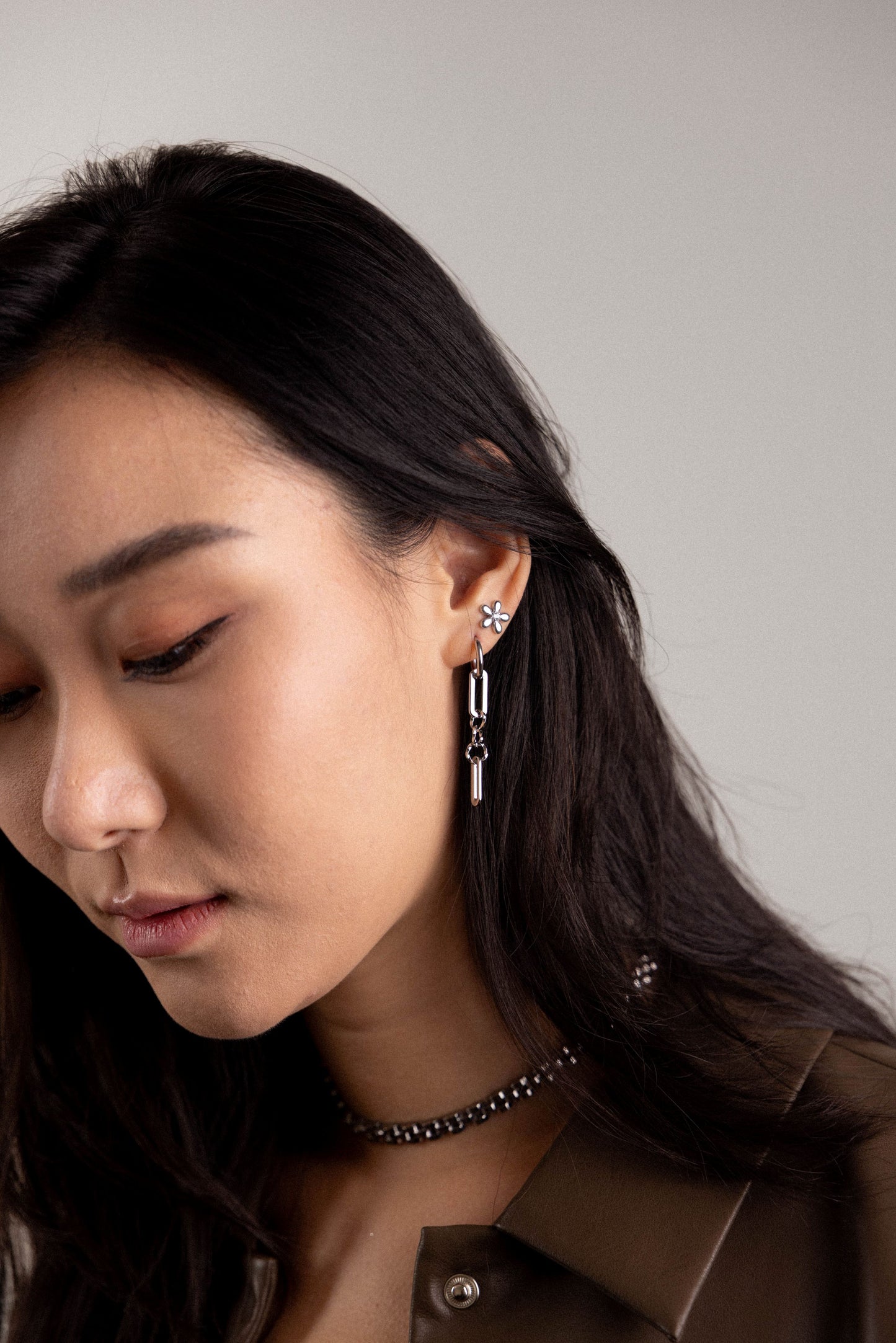 Close-up of a woman wearing earrings with a neutral background