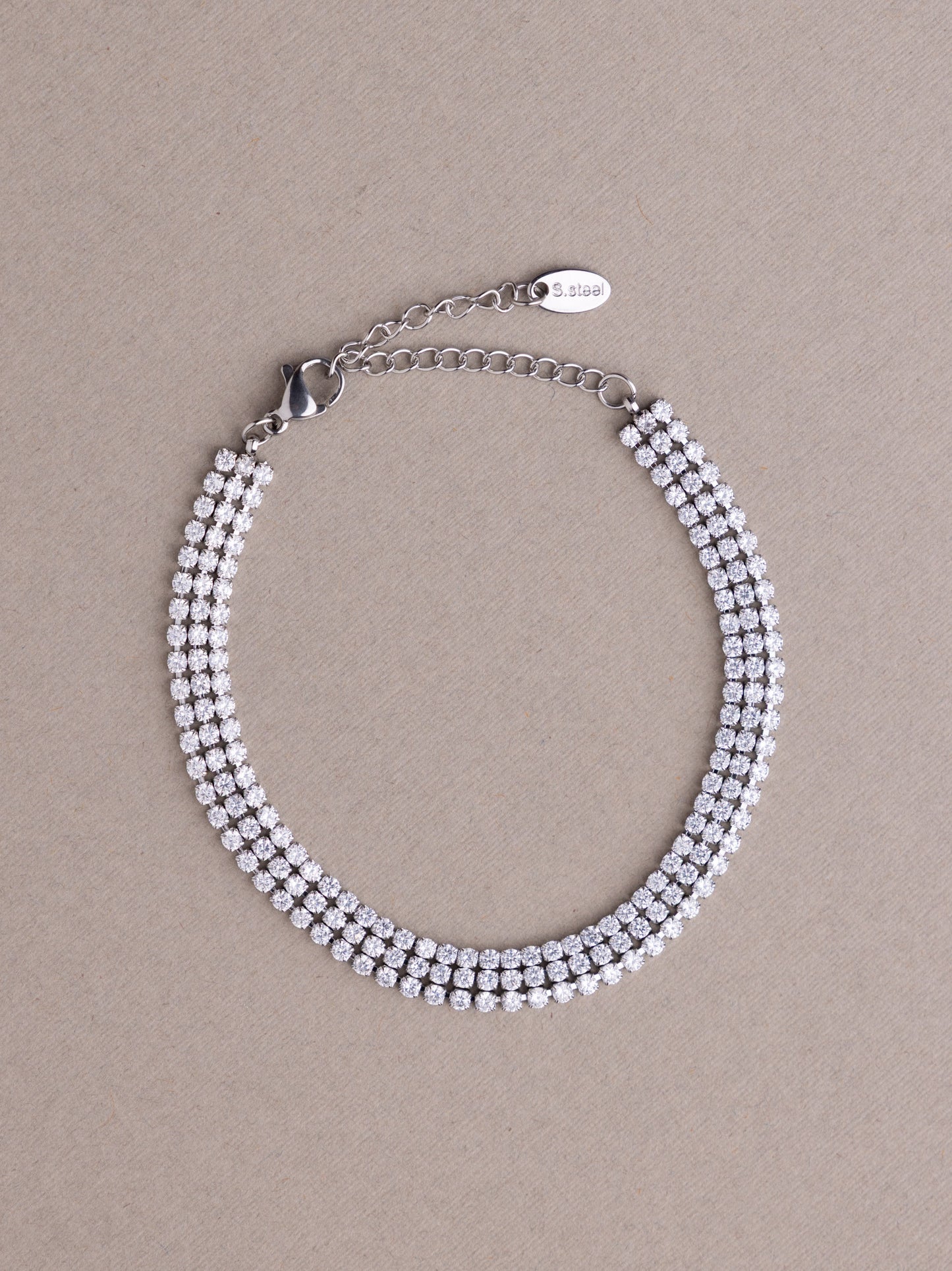 Silver beaded bracelet on a beige background