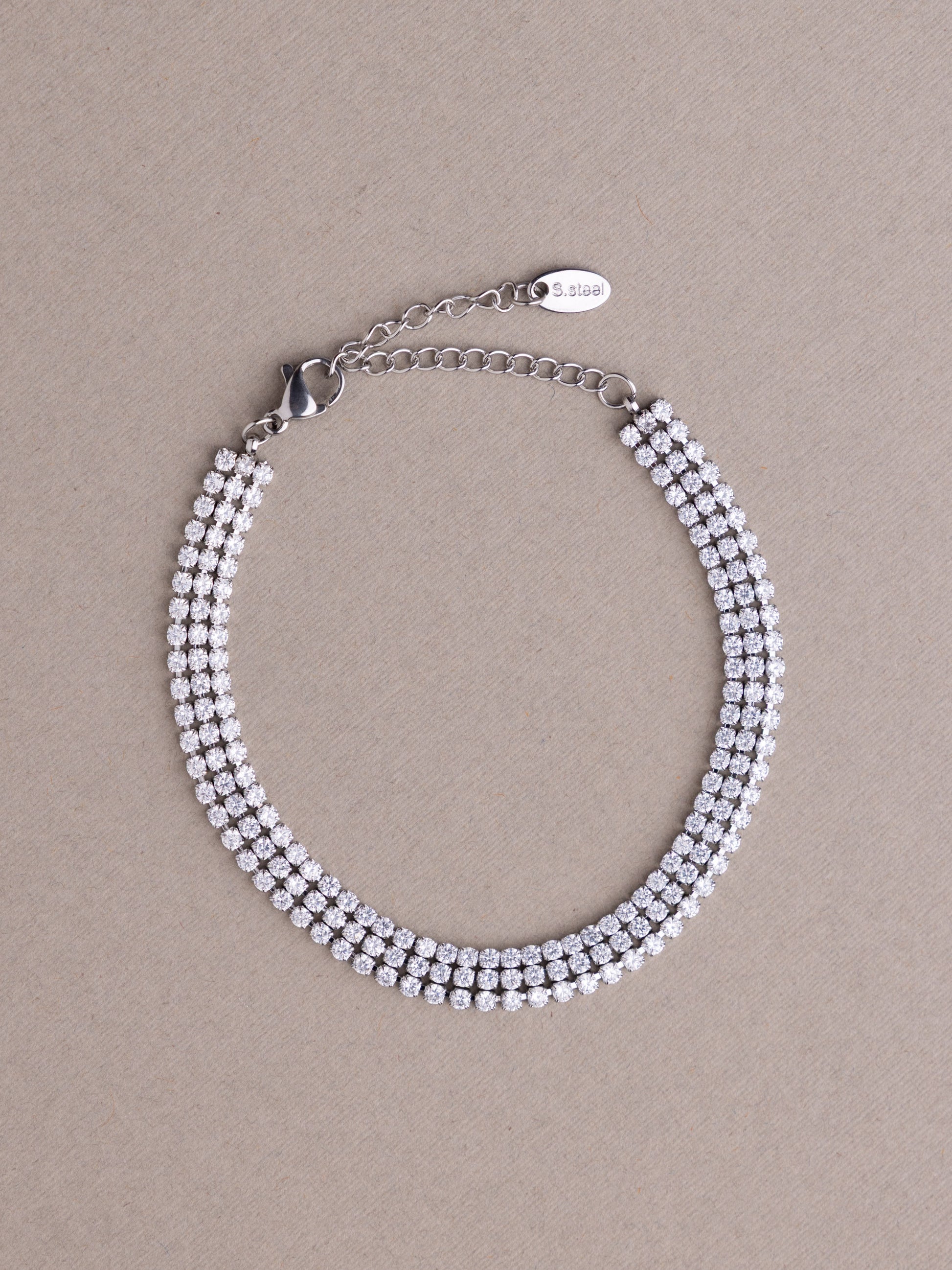 Silver beaded bracelet on a beige background
