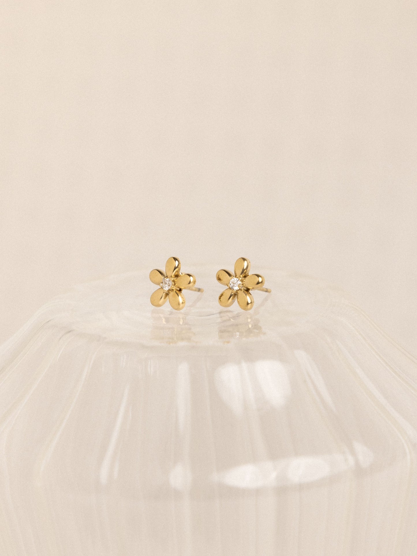 18k gold-plated flower earrings on beige background