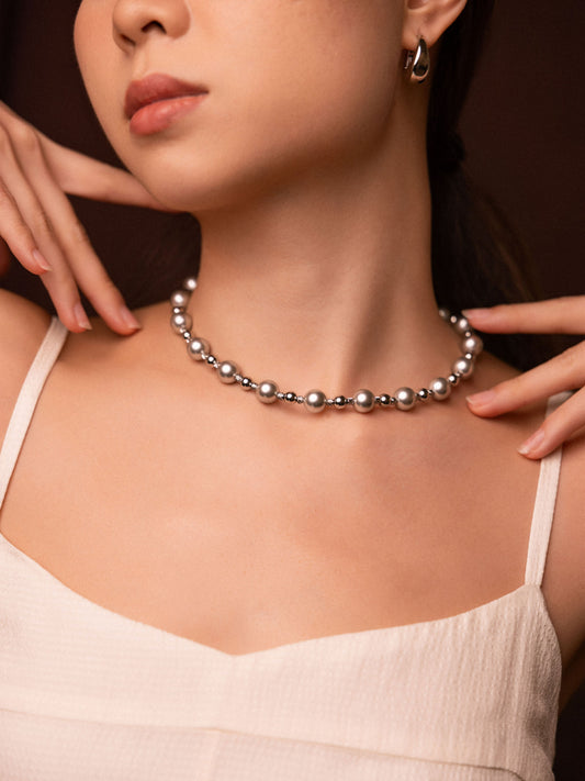 Woman wearing a pearl necklace with a neutral background